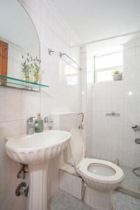 a white bathroom with a sink and a toilet at A4 - Rosemary Apartment in Nydri