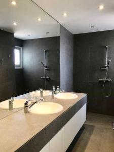La salle de bains est pourvue de 2 lavabos et d'un grand miroir. dans l'établissement Modern Apartment near the Center by Platform 357, à Strovolos