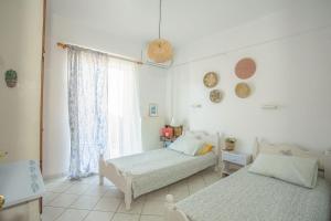 a bedroom with two beds and a window at A4 - Rosemary Apartment in Nydri