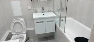 La salle de bains blanche est pourvue d'un lavabo et de toilettes. dans l'établissement Сдам в аренду квартиру, à Taldykolʼ