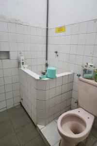 a bathroom with a toilet in a tiled room at OYO 93869 Regina Homestay Syariah in Surabaya