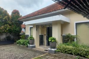 une maison avec des plantes devant elle dans l'établissement Capital O 93872 Natura Guest House Syariah, à Purwokerto