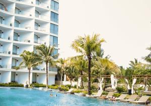uitzicht op een hotel en een zwembad met palmbomen bij Palmy Luxury Beach Phú Quốc in Phu Quoc