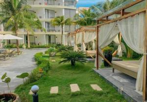 a hotel yard with a patio and a garden at Palmy Luxury Beach Phú Quốc in Phu Quoc