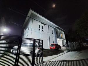 samochód zaparkowany w nocy przed białym domem w obiekcie OYO 93870 Damai Guest House Cirebon w mieście Cirebon