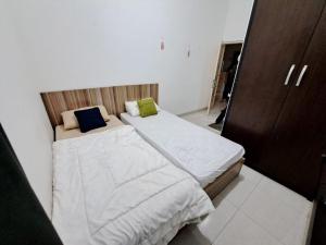 małą sypialnię z 2 łóżkami w pokoju w obiekcie OYO 93870 Damai Guest House Cirebon w mieście Cirebon