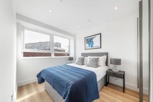 a white bedroom with a bed and a window at Bright Contemporary Studio in East Grinstead in East Grinstead