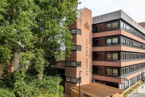 a tall brick building with a clock on it at Bright Contemporary Studio in East Grinstead in East Grinstead