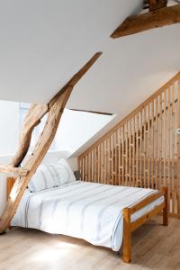 a bedroom with a large bed with a wooden frame at Les Frangines - maison de ville avec jardin Ault in Ault +17 photos