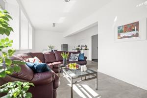 uma sala de estar com um sofá de couro castanho e uma mesa em Apartament Stylowy em Gdansk
