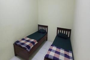 2 Betten nebeneinander in einem Zimmer in der Unterkunft OYO 93861 Adinda Guest House Syariah in Garut