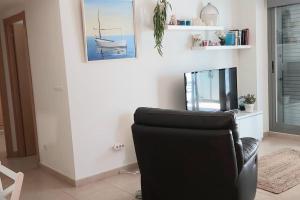 sala de estar con silla negra y espejo en Apartamento La Marjal, en Moncófar