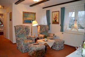 a living room with two chairs and a table at Nordseestübchen Whg 04 in Nieblum
