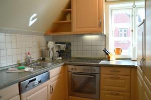 a kitchen with wooden cabinets and a sink and a window at Nordseestübchen Whg 01 in Nieblum