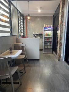 um restaurante com um frigorífico, uma mesa e cadeiras em Wilnags Inn Puerto Princesa near airport em Puerto Princesa
