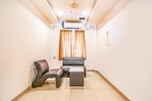 a waiting room with two chairs and a table at FabHotel Prime Royal Castle Gandhipuram in Coimbatore