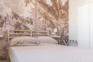 um quarto com uma cama com papel de parede tropical em Enjoy and Fly em Fiumicino