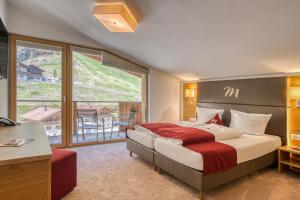 1 dormitorio con cama grande y ventana grande en Mallaun Hotel.Erlebnis, en See