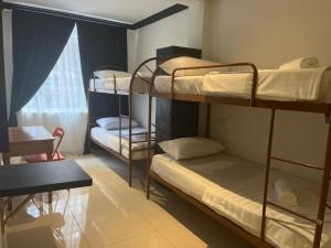 een slaapzaal met 3 stapelbedden en een raam bij OYO 90970 Senja Hostel Chinatown in Kuala Lumpur