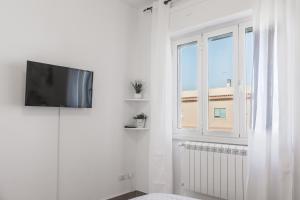a white room with a tv and a window at Enjoy and Fly in Fiumicino