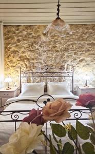 a bedroom with a bed with a stone wall at Arhontiko Arhanes Suites in Archanes