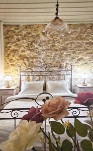 a bedroom with a bed with a stone wall at Villa Arhontiko In Arhanes in Archanes