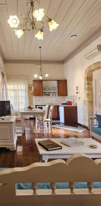 sala de estar amplia con mesa y cocina en Arhontiko Arhanes Suites, en Archanes