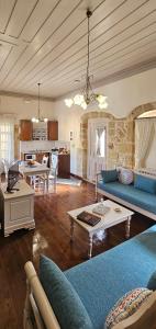 un soggiorno con divani blu e una cucina di Arhontiko Arhanes Suites ad Archanes