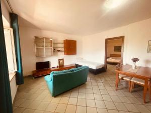 ein Wohnzimmer mit einem blauen Sofa und einem Bett in der Unterkunft casa vacanze spigolatrice in Sapri