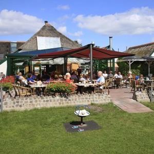 a group of people sitting at tables at a restaurant at vakantiehuisje Holterberg in Holten