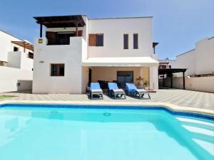 a villa with a swimming pool in front of a house at Casa Daniela in Costa Teguise