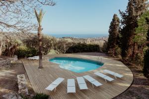 a swimming pool with white lounge chairs around it at Ca lAndreu Ecoturisme in Tiana