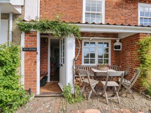 a brick house with a table and chairs at Beta Cottage in Southwold