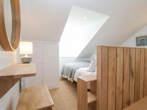 a attic bedroom with a bed and a window at Beta Cottage in Southwold