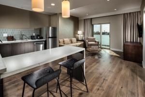 a kitchen and living room with a counter and chairs at Hotel Aventura in Los Angeles