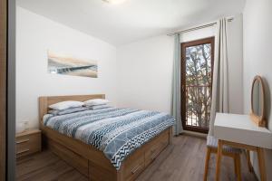 a white bedroom with a bed and a window at City market apartments Pula in Pula