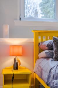 ein gelbes Schlafzimmer mit einem Bett und einer Lampe auf einem Nachttisch in der Unterkunft Ashvale Stay - SJA Stays - Unique 1 Bed Apartment in Aberdeen