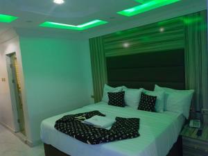 a bedroom with a large bed with green lights on it at Global Signature Hotel and Resort in Ibadan