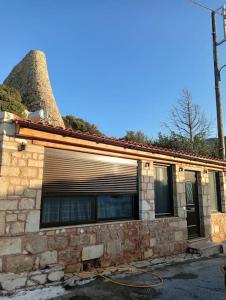 Agia FotiaにあるNeromilos Agia Fotia Sitiaの煙突のあるレンガ造りの建物と石造りの家