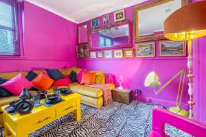 ein Wohnzimmer mit rosa Wänden und einem Sofa in der Unterkunft Ashvale Stay - SJA Stays - Unique 1 Bed Apartment in Aberdeen