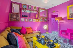 ein Wohnzimmer mit rosa Wänden und einem Sofa in der Unterkunft Ashvale Stay - SJA Stays - Unique 1 Bed Apartment in Aberdeen