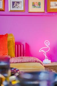Zimmer mit einer rosa Wand mit einem Flamingo-Neon-Schild in der Unterkunft Ashvale Stay - SJA Stays - Unique 1 Bed Apartment in Aberdeen