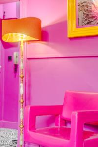 ein rosafarbenes Zimmer mit einem rosa Stuhl und einer Lampe in der Unterkunft Ashvale Stay - SJA Stays - Unique 1 Bed Apartment in Aberdeen