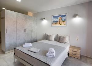 ein Schlafzimmer mit einem Bett mit zwei Handtüchern darauf in der Unterkunft Excess Pansion in Lefkada Town