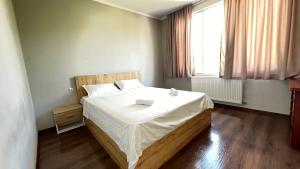 - une chambre dotée d'un grand lit avec des draps blancs et une fenêtre dans l'établissement Garden House Tbilisi, à Tbilissi 43 autres photos