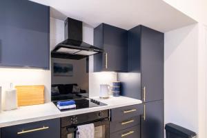 a kitchen with black cabinets and a stove top oven at Willowstay - SJA Stays - Modern 2 Bed Apartment in Aberdeen