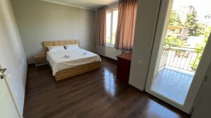 une petite chambre avec un lit et un balcon dans l'établissement Garden House Tbilisi, à Tbilissi