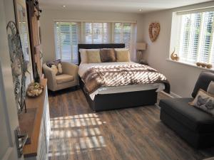 a bedroom with a bed and a couch and a chair at Good stay at 91 in Silsden