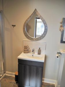 uma casa de banho com um lavatório e um espelho na parede em Good stay at 91 em Silsden