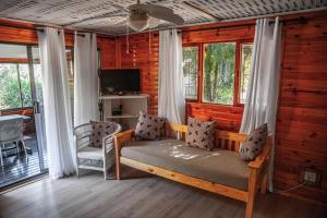 Bonnievale的住宿－Olifantskrans River Cabins，小屋内带床和椅子的房间
